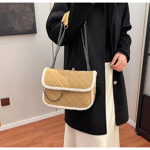 Detail of khaki quilted shoulder bag with white faux fur trim and silver chain