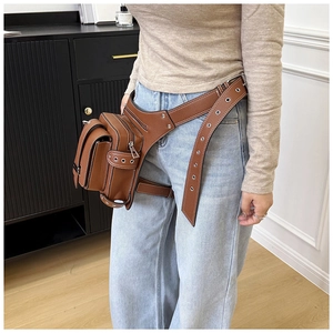 Détail du sac de jambe en cuir marron avec œillets métalliques et sangles réglables