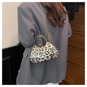 Detail of leopard print evening clutch with gold circular handle and metal chain strap