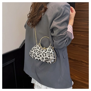 Detail view of leopard print clutch bag with gold ring handle and chain strap