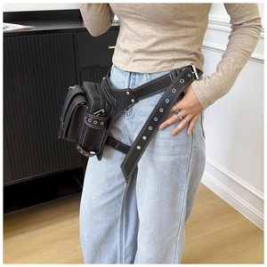 Détail du sac de jambe en similicuir noir avec rivets argentés et sangles de taille réglables