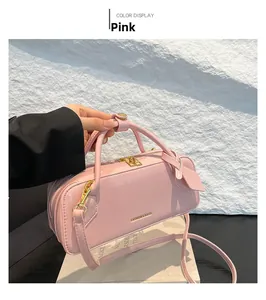 Detail of pink glossy shoulder bag with gold zippers and adjustable strap