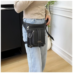 Détail du sac de jambe en cuir noir grainé avec chaîne argentée et sangles réglables
