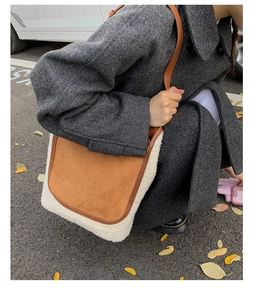 Detail of winter tote bag featuring brown suede fabric and white faux shearling trim