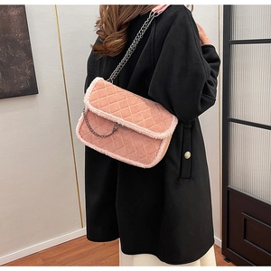 Close-up of pink quilted crossbody bag with white faux fur trim and black metal chain