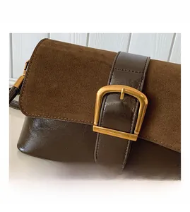 Detail of a brown flap handbag featuring contrast textures and a gold D-ring buckle