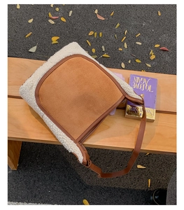Autumn style brown suede tote bag with white faux shearling trim on a wooden bench