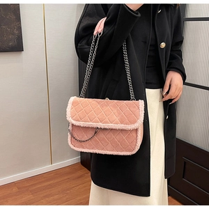 Pink quilted shoulder bag with faux shearling trim worn by a model in black coat
