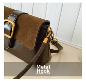 Detail view of gold-tone metal hardware and leather stitching on dark brown handbag
