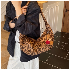 Detail of leopard print suede hobo bag with plush pom-pom charm and pleated bottom
