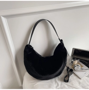 Vue détaillée du sac croissant en fausse fourrure noire avec bandoulière en cuir souple