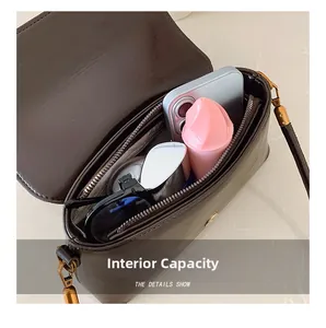 Detail showing internal capacity of the dark brown leather shoulder bag with daily items