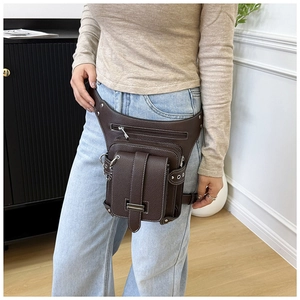 Détail du sac de jambe en cuir marron foncé avec rivets punk vintage et sangles