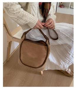 Detail view of winter brown suede tote bag with beige faux fur trim and leather strap