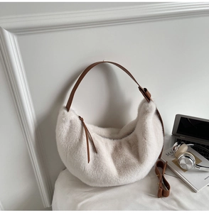 Détail du sac croissant en fausse fourrure crème avec bandoulières en cuir marron