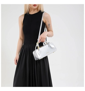 Polished silver cylinder baguette bag with gold metal hardware and detachable strap