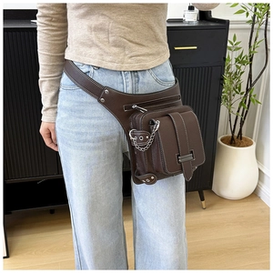 Detail of dark brown leather waist bag with contrast stitching and metal chains
