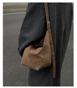 Detailed macro view of the vintage brown suede hobo bag with adjustable strap and metal eyelets