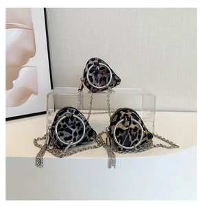 Dettaglio di tre mini borse leopardate con manici ad anello d'argento e nappe in metallo