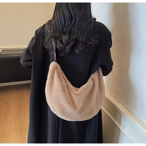 Détail du sac hobo en peluche chameau porté à l'épaule montrant la texture douce
