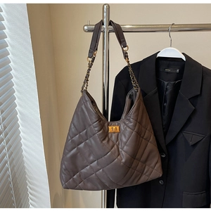 Close-up of coffee brown quilted leather bag with vintage gold turn-lock and chain strap