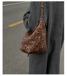 Close-up of a large leopard print shoulder bag worn with a grey wool coat in street style