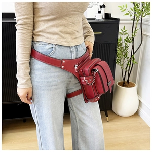 Detail of red leather thigh bag with lychee pattern texture and metal chain