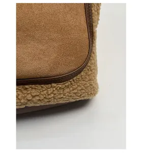 Detail of suede and faux shearling patchwork bucket bag with leather piping