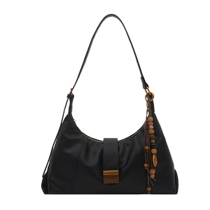 Black leather hobo shoulder bag with a metal buckle and bohemian beaded tassel charm