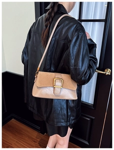 Detail of retro shoulder bag featuring beige leather and brown suede with gold buckle