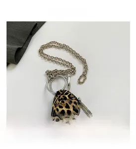 Dettaglio mini borsa a triangolo leopardata con manico ad anello e frange di strass