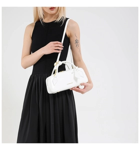 Detailed close-up of white leather baguette bag with gold zippers and hardware