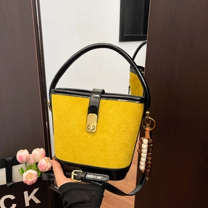 Sac seau vintage en daim jaune avec surpiqûres en losange et pompon en perles de bois