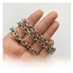 Dettaglio della catena in metallo argento con anelli ovali lucidi tenuta in mano