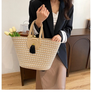 Detail of hand-woven striped tote bag with elegant black tassel and circular weave pattern