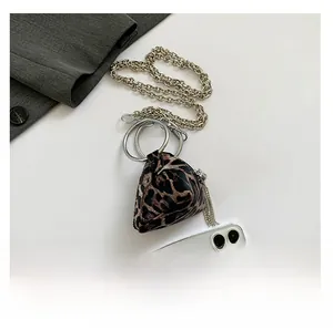 Vista dettagliata della mini borsa leopardata con catena argentata e nappina sulla zip