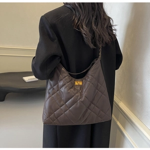 Deep brown quilted hobo bag with gold twist-lock and chain strap shown on person