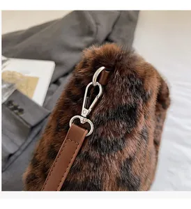 Detail of high-gloss metallic hardware and leopard print faux fur texture of the handbag