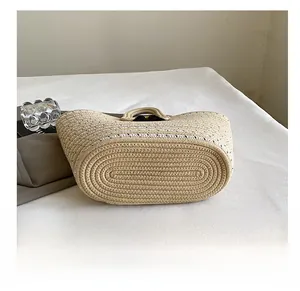 Detail showing the oval woven base and tight craftsmanship of the straw handbag