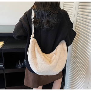 Detailed view of cream plush dumpling bag featuring soft faux fur texture and leather strap