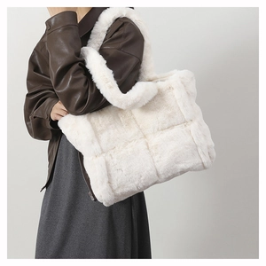 Close-up of plush faux fur tote bag with quilted stitching on a female model