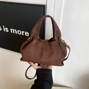 Fashionable dark brown suede crossbody handbag with golden hardware and top handle