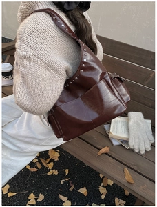 Deep brown vintage shoulder bag with silver rivets shown in an autumn lifestyle setting