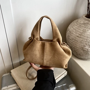 Minimalist tan suede half-moon handbag with wide handle and detachable shoulder strap
