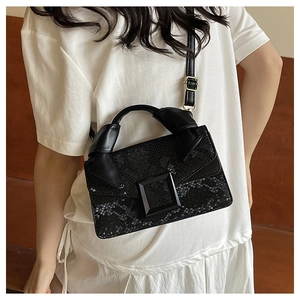 Close-up of the black snake pattern leather handbag with its large square decorative buckle
