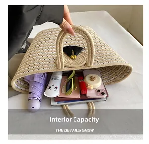 Internal capacity of woven straw tote bag showing umbrella, tablet, and cosmetics