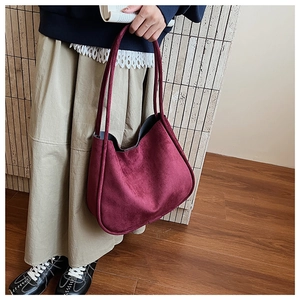 Detail of burgundy suede tote bag showing the matte texture and double handles
