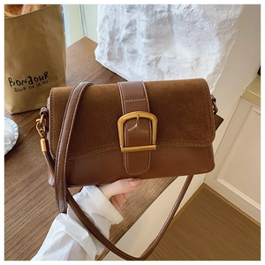 Detail of vintage coffee shoulder bag with textured suede flap and gold buckle closure
