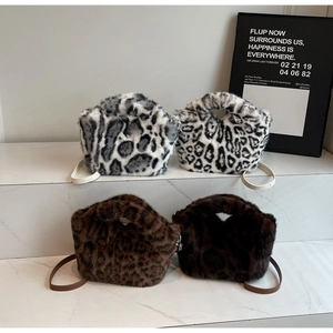 Detail of four faux fur leopard print handbags on marble stairs showing textures