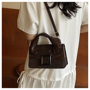 Detail of vintage brown snake-print crossbody bag with knot handle and square buckle